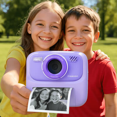 Deux enfants souriants utilisant un appareil photo enfant violet avec impression instantanée, photo prise en plein air dans un parc