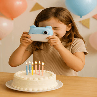 fillette prenant en photo un gĂąteau dâanniversaire avec un appareil photo enfant