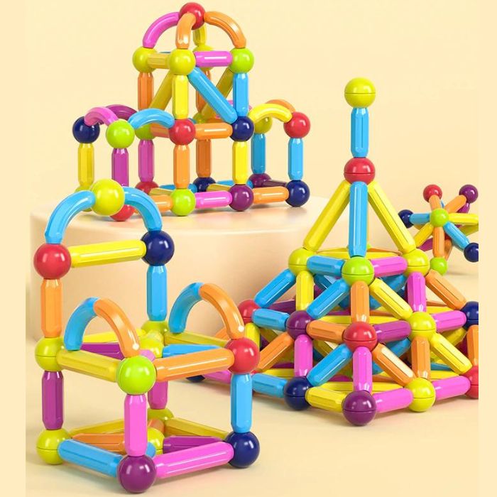 Enfant de 4 ans qui joue avec ses grand-parents dans le salon avec un jeu de construction magnétique et jeu aimanté