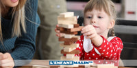 jeune fille qui joue avec un jeu de construction en bois développement de la motricité fine