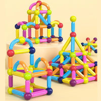 Enfant de 4 ans qui joue avec ses grand-parents dans le salon avec un jeu de construction magnétique et jeu aimanté
